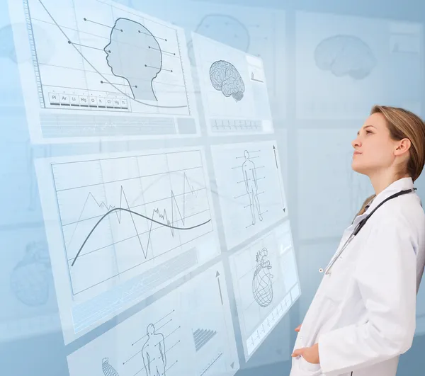 Thoughtful doctor looking at a medical new technology — Stock Photo, Image