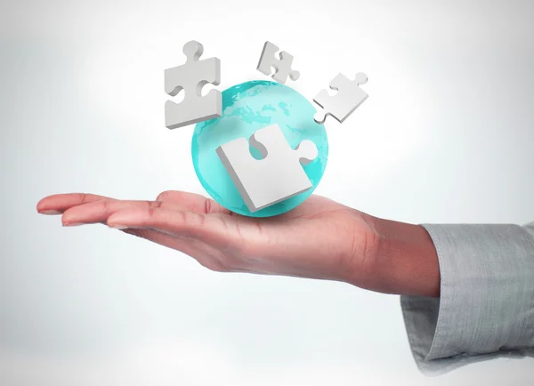 Hand with digital puzzles and a globe — Stock Photo, Image