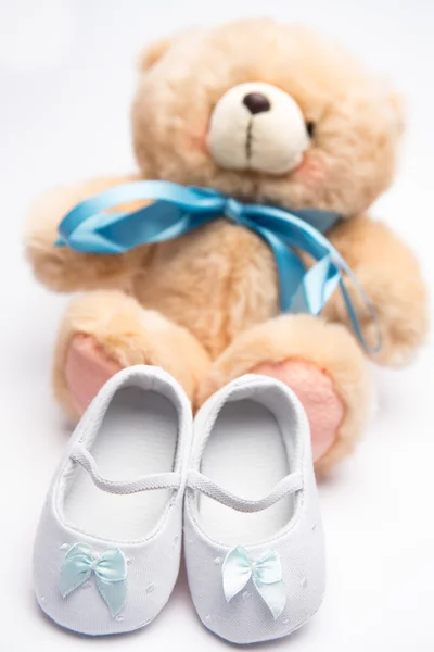 Teddybeer met blauw lint en witte slofjes — Stockfoto