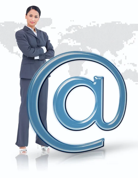 Деловая женщина, стоящая по синей электронной почте на символ — стоковое фото