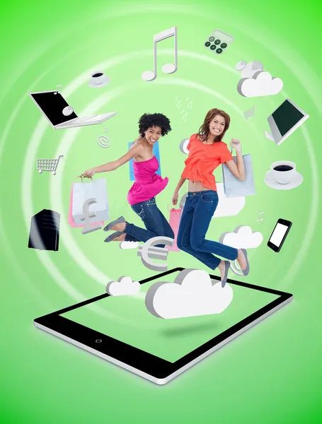 Dwie kobiety szczęśliwy, skoki na komputerze typu tablet — Zdjęcie stockowe