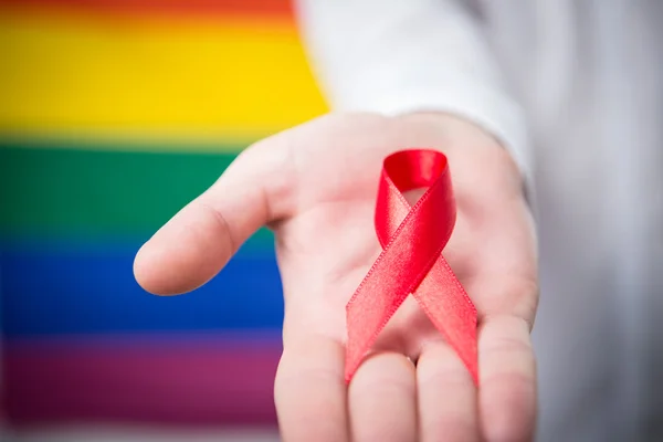 Man holding red awareness ribbon — Zdjęcie stockowe