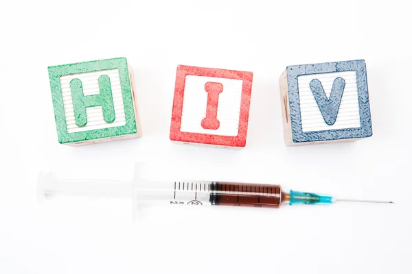 Blocchi di legno in verde e rosso ortografia hiv con siringa — Foto Stock