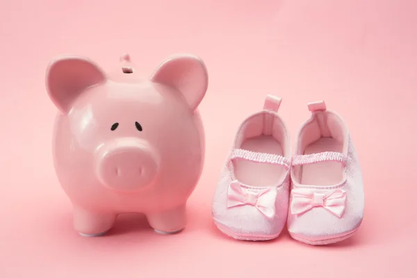 Piggy bank and baby booties — Stock Photo, Image
