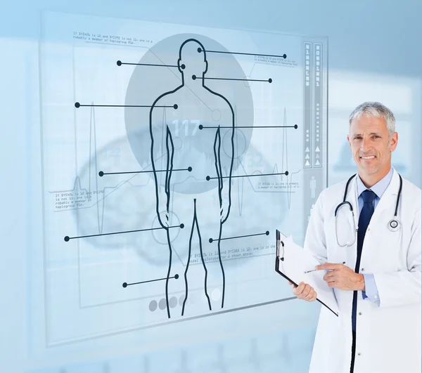 Senior doctor holding a clipboard beside futuristic screens — Stock Photo, Image