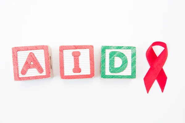 Wood kvarter stava ut aids i grönt och rött med awareness ribbon — Stockfoto