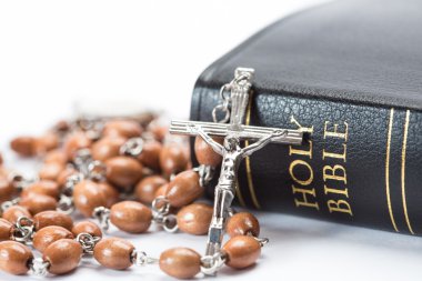 Black leather bound holy bible with rosary beads clipart