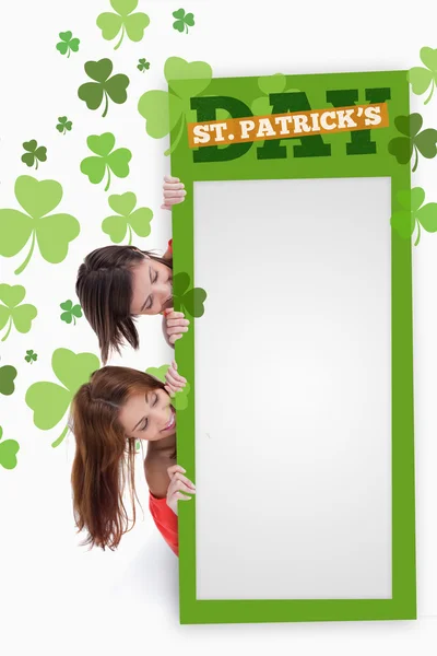 Meninas segurando cartaz verde em branco com patricks texto do dia — Fotografia de Stock
