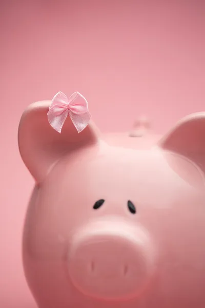 Piggy bank wearing pink ribbon — Stock Photo, Image