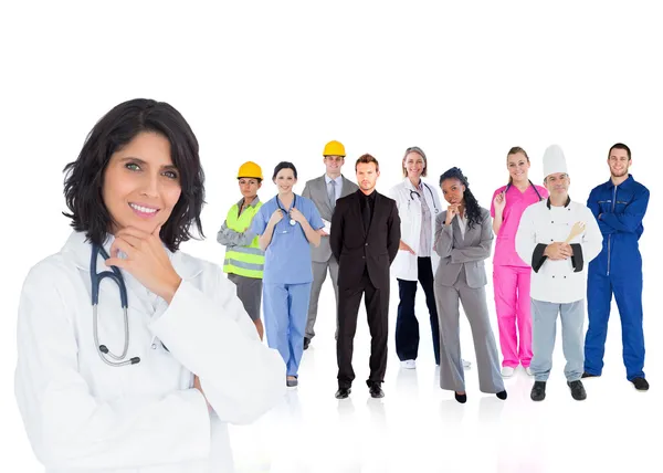 Médico sonriendo con varios trabajadores detrás de ella — Foto de Stock