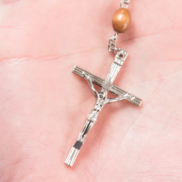 Cross of rosary beads in hand — Stock Photo, Image