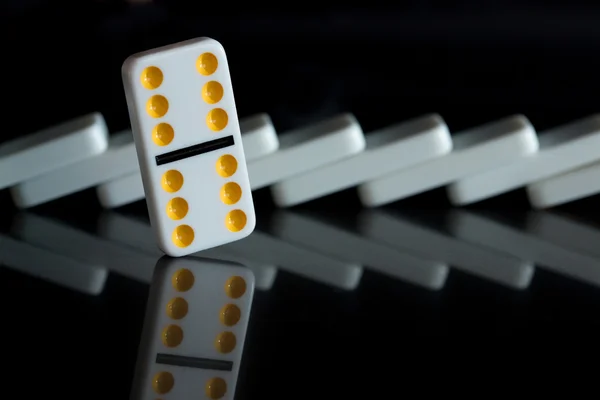 One yellow domino standing in front of knocked line — Stock Photo, Image