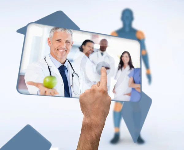 Hand selecting image of doctor holding apple in digital interface — Stock Photo, Image