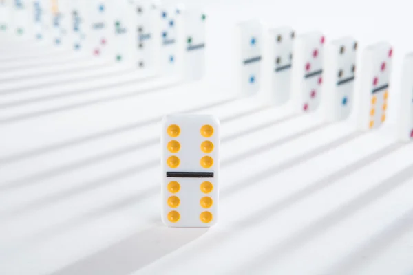 One yellow domino standing in front of line of dominoes — Stock Photo, Image