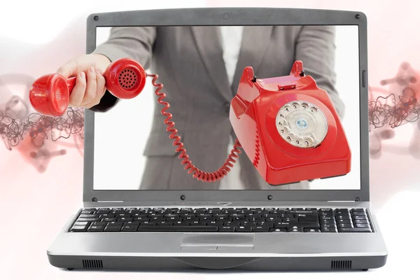 Woman reaching out from laptop handing phone receiver — Stock Photo, Image