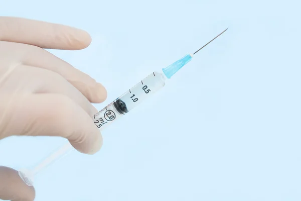 Gloved hand holding syringe — Stock Photo, Image