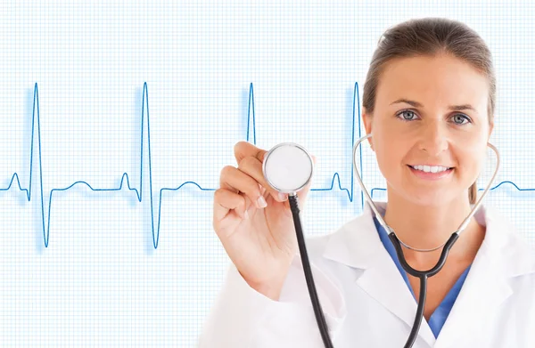 Doctor holding up stethoscope with blue ECG line — Stock Photo, Image