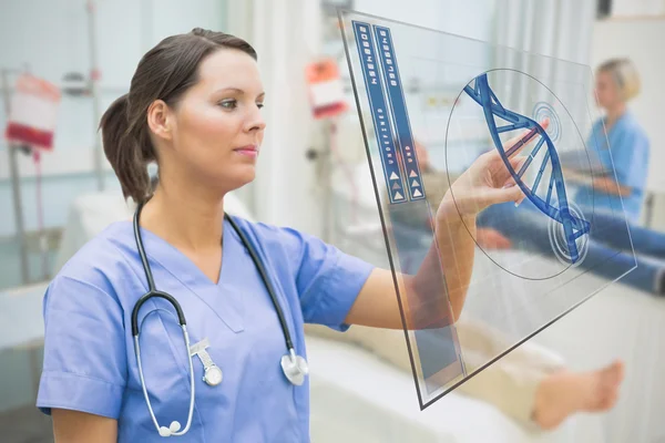 Nurse touching screen displaying blue DNA helix data — Stock Photo, Image