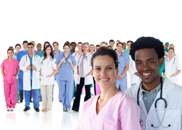 Médecins souriants devant une équipe de médecins debout ensemble — Photo
