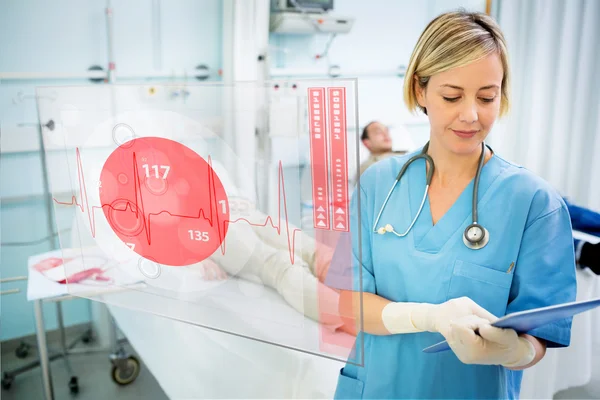 Nurse consulting tablet with screen displaying ECG in foreground — Stock Photo, Image