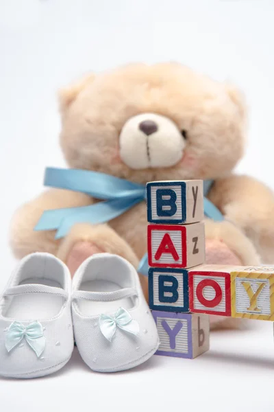 Blocks spelling baby boy with teddy and baby shoes — Stock Photo, Image