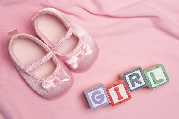 Baby girl spelled out in blocks with pink booties — Stock Photo, Image