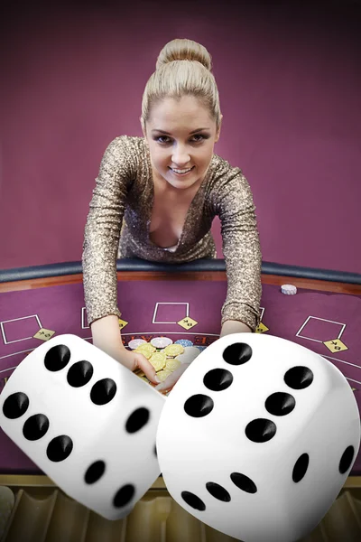 Blonde woman grabbing chips with digital dice — Stock Photo, Image