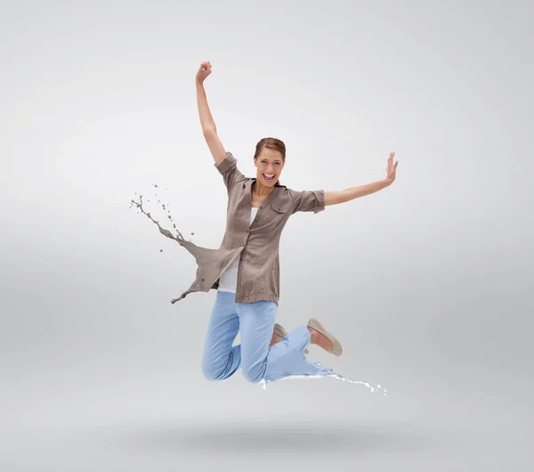 Frau springt mit Kleidern, die zu Farbspritzern werden — Stockfoto