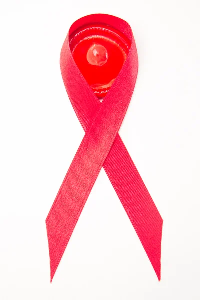 Red aids ribbon with condom — Stock Photo, Image