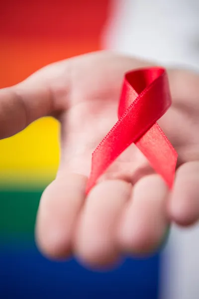 Man holding red aids awareness ribbon — Stock Photo, Image