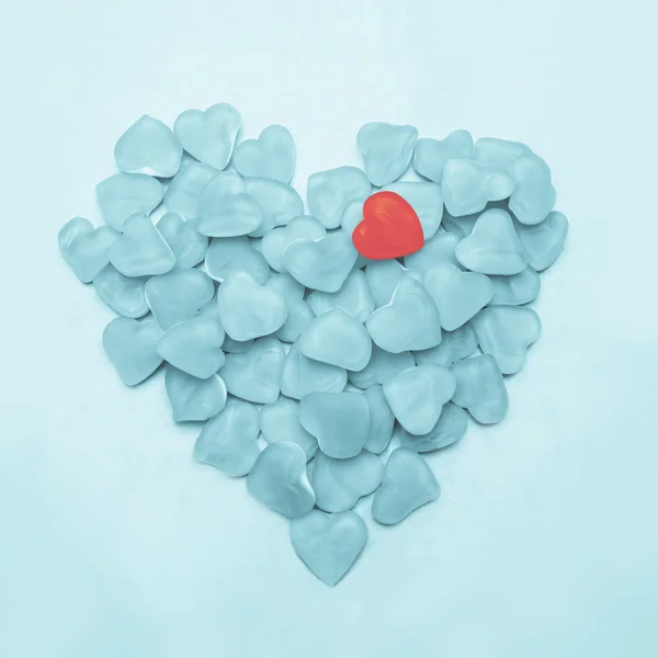 Blue heart made of candy with one pink heart — Stock Photo, Image