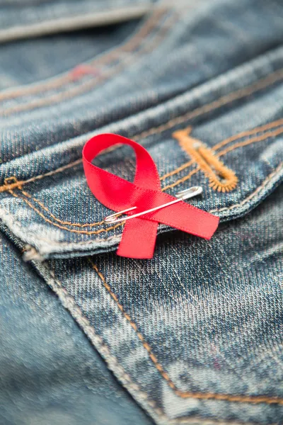 ジーンズのポケットに固定されているエイズ意識のリボン — ストック写真
