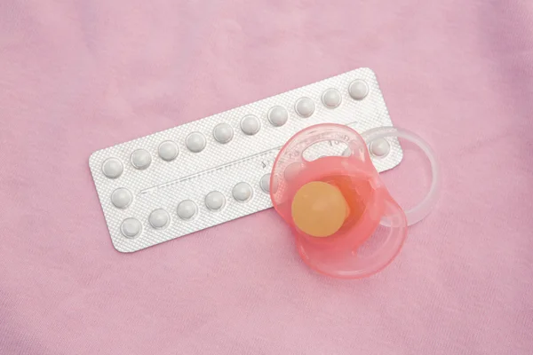 Contraceptive pill packet with pink soother — Stock Photo, Image