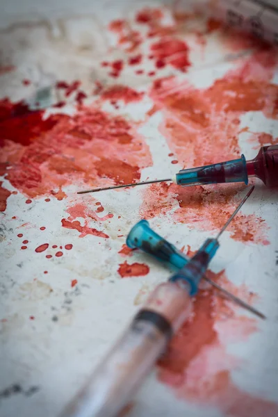 Two syringes lying on blood splatters — Stock Photo, Image