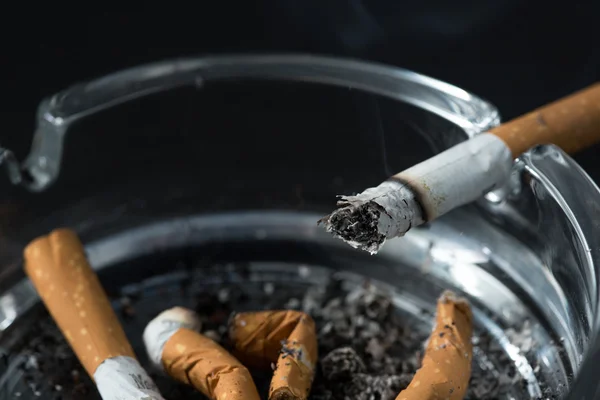 Burning cigarette butt in ashtray — Stock Photo, Image