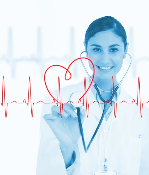 Doctor holding stethoscope up to ECG line — Stock Photo, Image