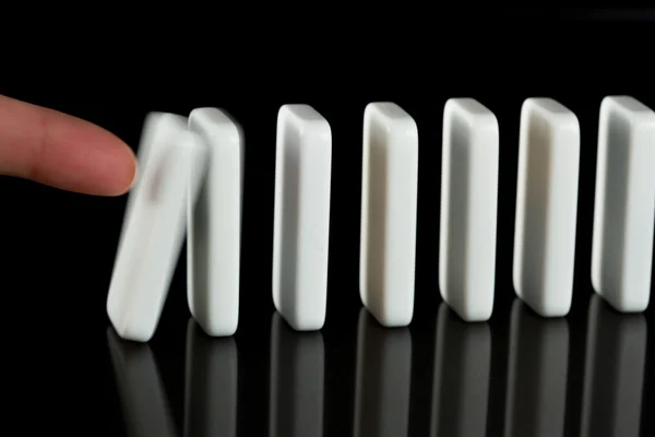 Finger drücken über Dominosteine — Stockfoto