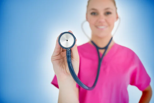 Happy nurse holding up stethoscope — Stock Photo, Image