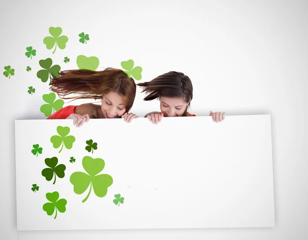 Flickor som tittar ner på Tom plakat med shamrocks — Stockfoto