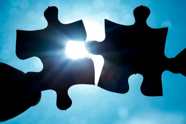 Hand holding two jigsaw pieces — Stock Photo, Image