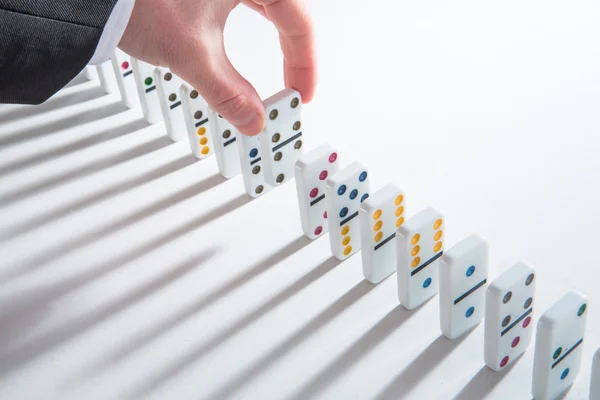 Hand placing domino into line of dominoes — Stock Photo, Image