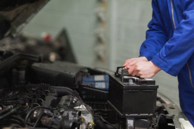 Mechanic changing car battery clipart