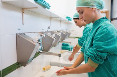 Two surgeons washing their hands clipart