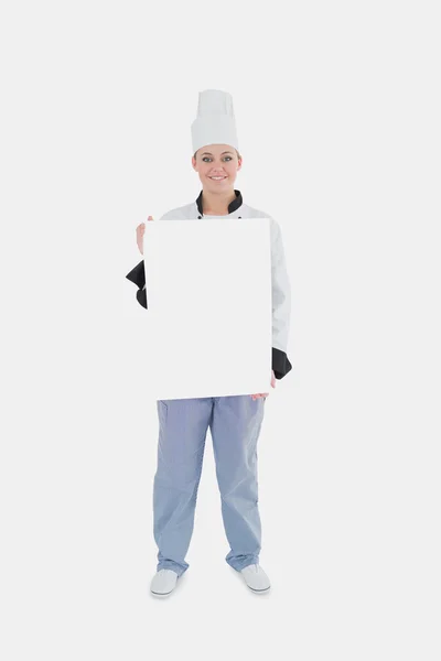 Female chef holding blank billboard — Stock Photo, Image