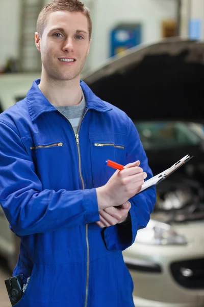 Mechanic writing on clipboard — Stock Photo, Image