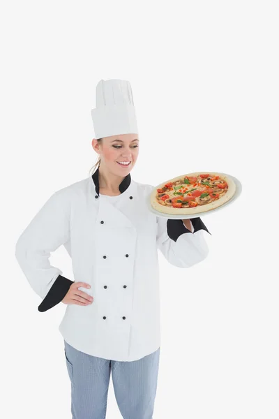 Chef feminino olhando para pizza — Fotografia de Stock