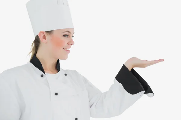 Happy female chef looking at invisible product — Stock Photo, Image