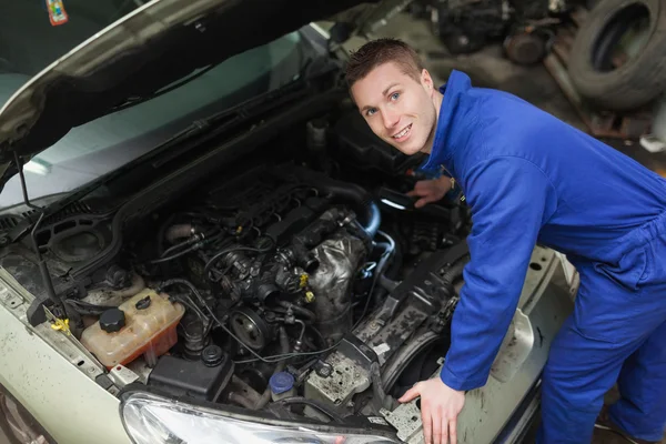 Happy mechanic examining car engine — Stock Photo, Image