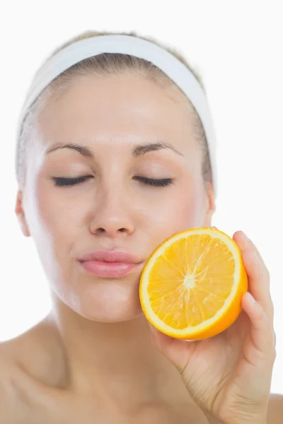 Young woman with eyes closed holding orange slice — Stock Photo, Image