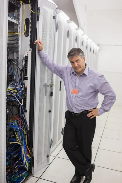 Hombre de pie junto a una torre de servidores — Foto de Stock